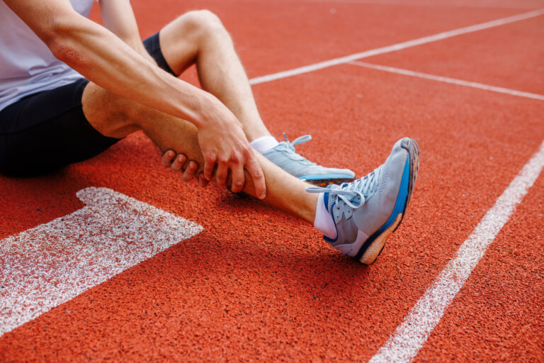 Runner on a track holding his shin