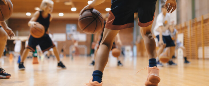 Junior level basketball player bouncing basketball